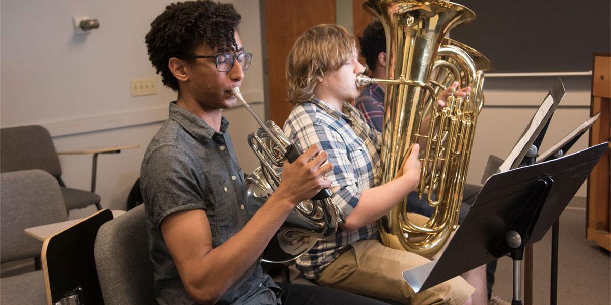 AACC students playing brass instruments in a classroom.